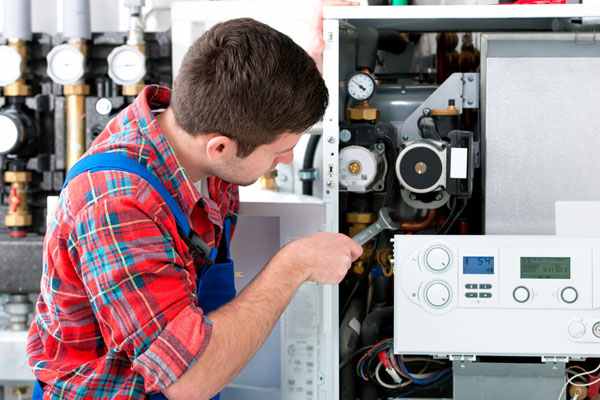 Heating technician repairing boiler controls in Camarillo