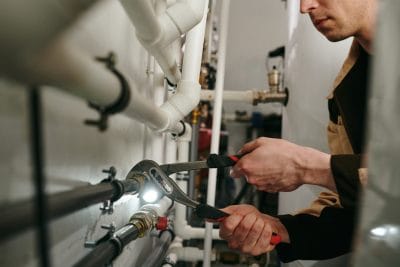 Technician inspecting commercial plumbing pipes in Camarillo