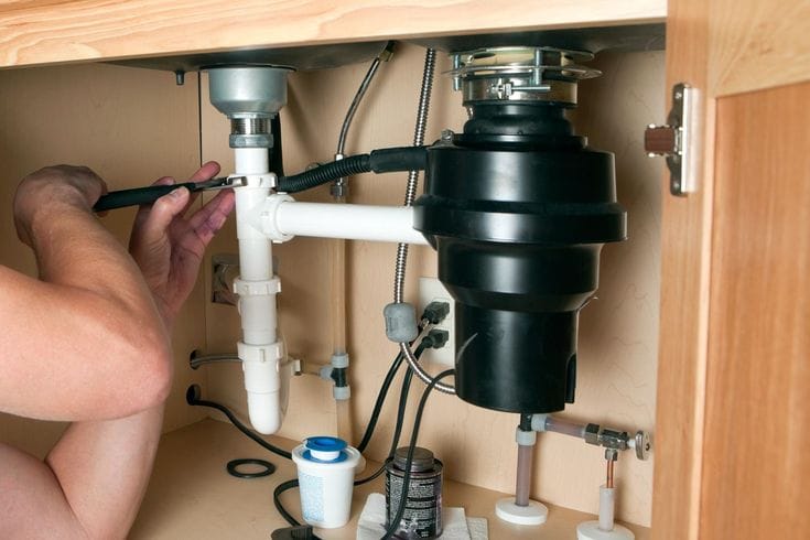 Plumber repairing a garbage disposal in Camarillo