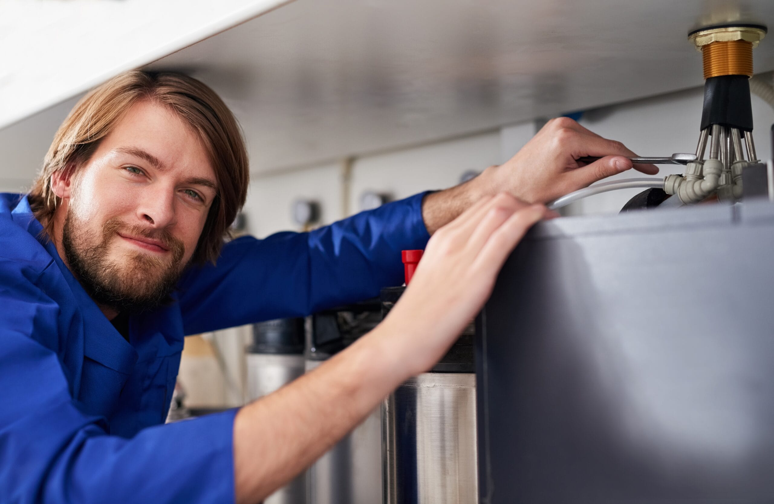 Technician servicing a residential water heater tank in Camarillo