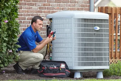 HVAC technician inspecting an outdoor AC unit in Camarillo
